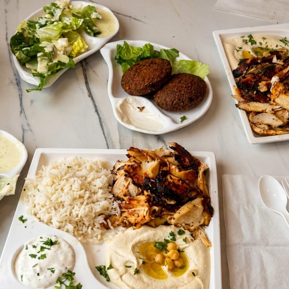 Starbox Falafel dishes: two chicken shawarma plates with rice and hummus, falafel, and salads.