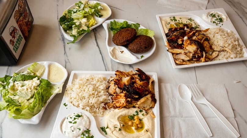 Starbox Falafel dishes: two chicken shawarma plates with rice and hummus, falafel, and salads.